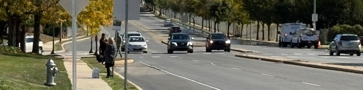 Wide shot of Cheltenham Avenue with cars, pedestrians, and bus